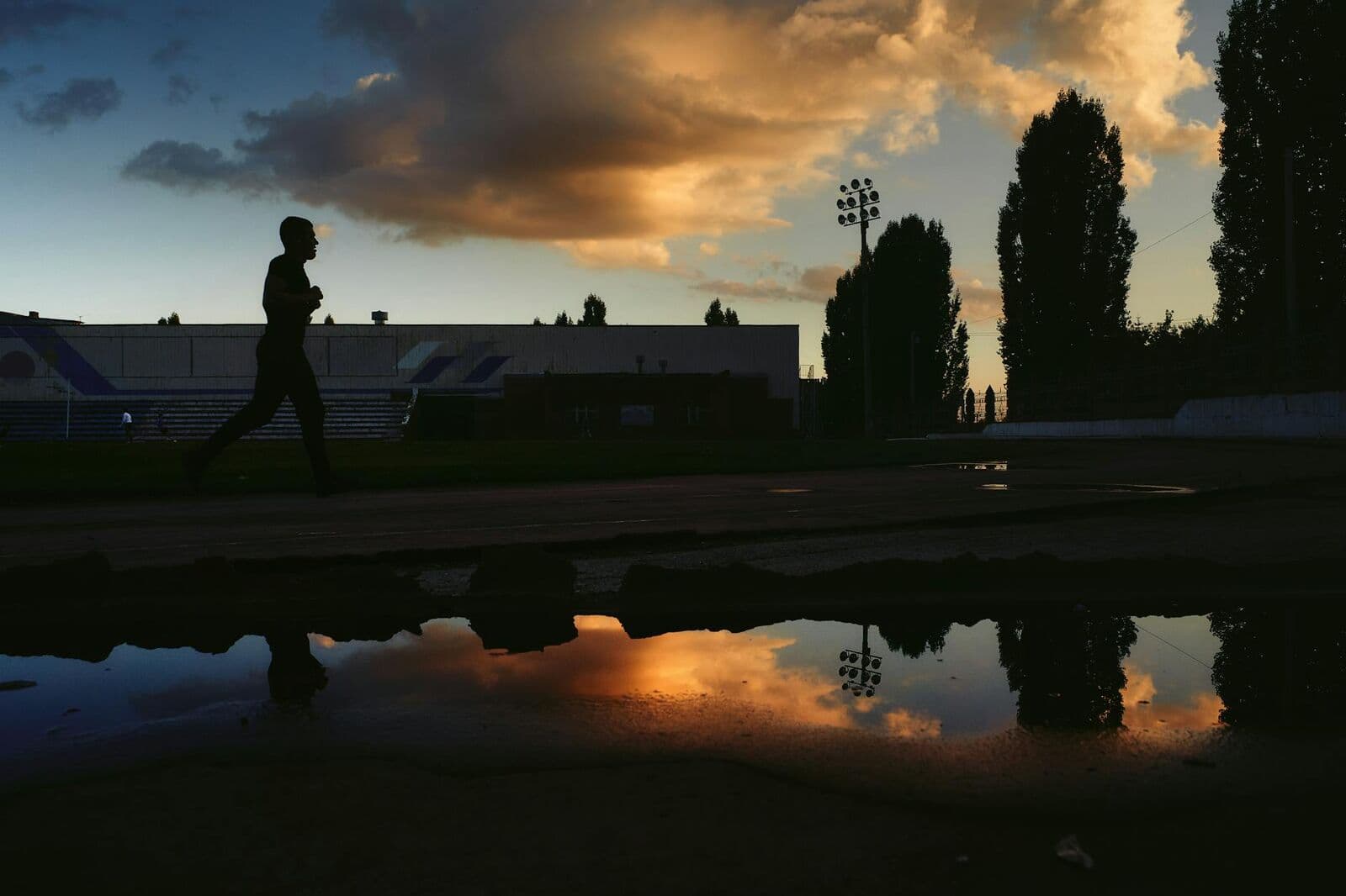 A person running on an open road at sunrise
